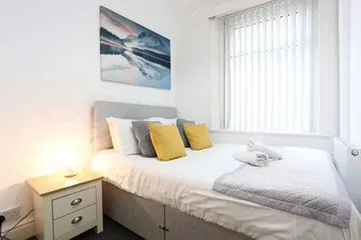 a bedroom with a bed with yellow pillows and a window at Avalanche 1 Bed Apartment in Blackpool