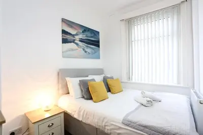 a bedroom with a bed with yellow pillows and a window at Avalanche 1 Bed Apartment in Blackpool