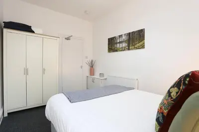 a bedroom with a white bed and white cabinets at Big Dipper 2 Bed Pleasure Beach in Blackpool