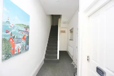 a hallway with a staircase and a painting on the wall at Big Dipper 2 Bed Pleasure Beach in Blackpool