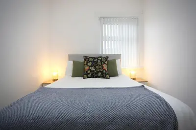a bedroom with a large bed with two lamps at Big Dipper 2 Bed Pleasure Beach in Blackpool