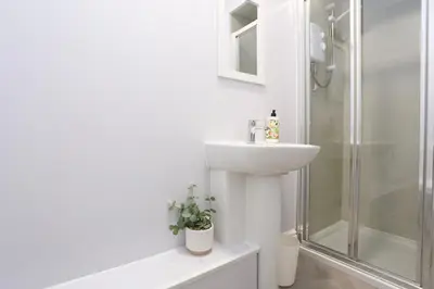 a white bathroom with a sink and a shower at Big Dipper 2 Bed Pleasure Beach in Blackpool