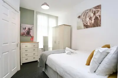 a bedroom with a bed and a dresser in it at Grand National 1-Bed Very Close to Pleasure Beach in Blackpool