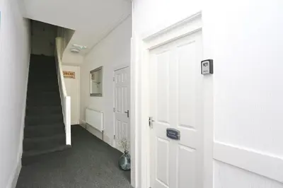 a hallway with a white door and a staircase at Grand National 1-Bed Very Close to Pleasure Beach in Blackpool
