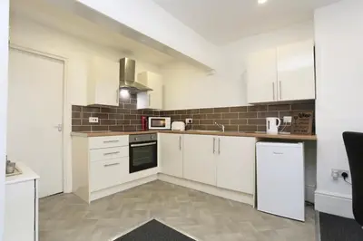 a kitchen with white cabinets and white appliances at Grand National 1-Bed Very Close to Pleasure Beach in Blackpool