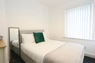 a bedroom with a bed with a green pillow on it at Ice Blast 1 Bed Pleasure Beach in Blackpool