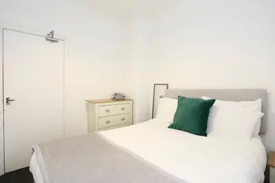 a bedroom with a white bed with a green pillow at Ice Blast 1 Bed Pleasure Beach in Blackpool