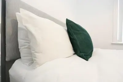 a green pillow sitting on top of a white bed at Ice Blast 1 Bed Pleasure Beach in Blackpool