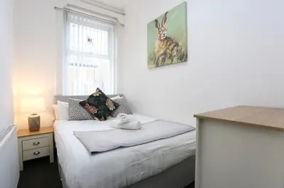 a bedroom with a bed with a stuffed animal on it at Pepsi Max 3 Bed Apartment 2 Bathroom close to Pleasure Beach in Blackpool