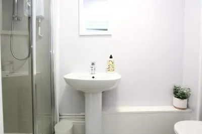 a white bathroom with a sink and a shower at Pepsi Max 3 Bed Apartment 2 Bathroom close to Pleasure Beach in Blackpool