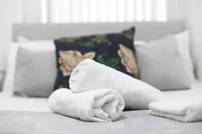 a stack of towels on a bed with pillows at Pepsi Max 3 Bed Apartment 2 Bathroom close to Pleasure Beach in Blackpool