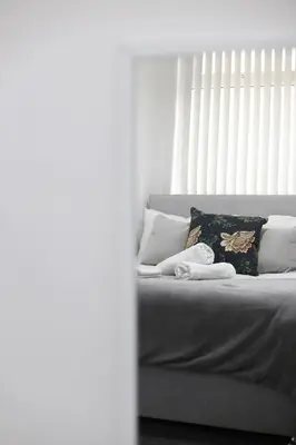 a white bed with a pillow and a blanket at Pepsi Max 3 Bed Apartment 2 Bathroom close to Pleasure Beach in Blackpool