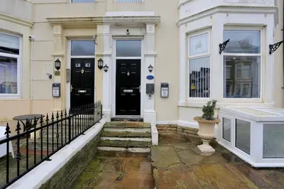 a building with black doors and a fence at Pepsi Max 3 Bed Apartment 2 Bathroom close to Pleasure Beach in Blackpool