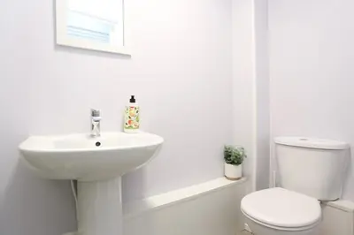 a white bathroom with a toilet and a sink at Pepsi Max 3 Bed Apartment 2 Bathroom close to Pleasure Beach in Blackpool