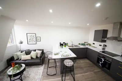 a kitchen and living room with a couch and a table at Spacious 2 Bedroom Apartment in Central Preston in Preston