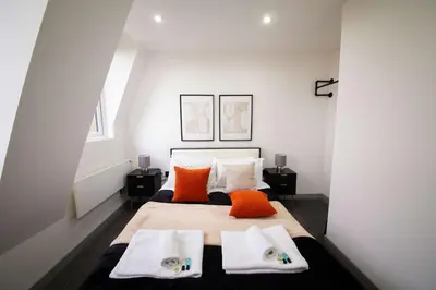 a bedroom with a bed with orange and white pillows at Spacious 2 Bedroom Apartment in Central Preston in Preston