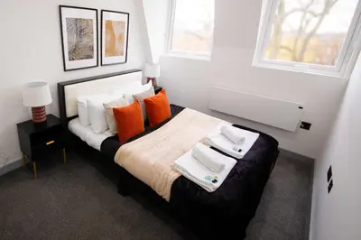 a bedroom with a bed with orange and white pillows at Spacious 2 Bedroom Apartment in Central Preston in Preston