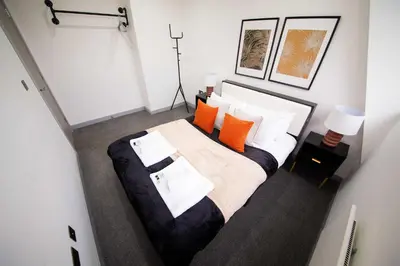 a bedroom with a large bed with orange and white pillows at Spacious 2 Bedroom Apartment in Central Preston in Preston