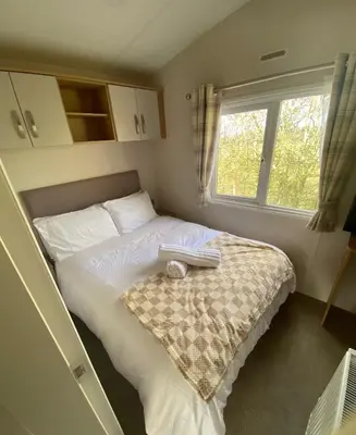 a bedroom with a bed with a book on it at Westfield Lodge Retreat-Sleeps 6-Pet Friendly in Carnforth