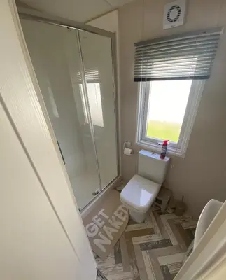 a bathroom with a toilet and a glass shower at Westfield Lodge Retreat-Sleeps 6-Pet Friendly in Carnforth