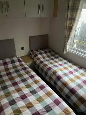 two beds sitting in a room with a window at Westfield Lodge Retreat-Sleeps 6-Pet Friendly in Carnforth