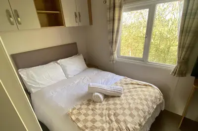 a bedroom with a bed with white sheets and a window at Westfield Lodge Retreat-Sleeps 6-Pet Friendly in Carnforth