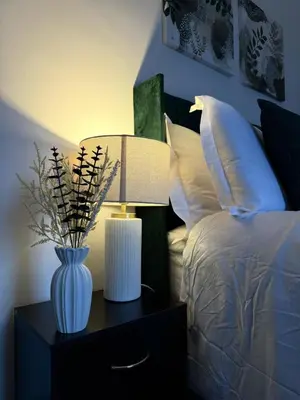 a lamp on a night stand next to a bed at 3BR Accommodation in St Helens - Sleeps 6 in Saint Helens