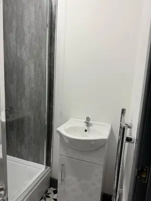 a white bathroom with a sink and a shower at 3BR Accommodation in St Helens - Sleeps 6 in Saint Helens