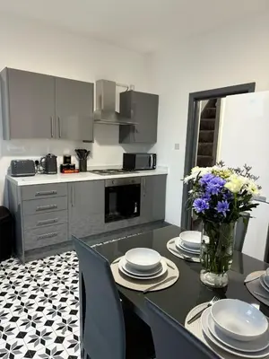 a kitchen with a table with plates and flowers on it at 3BR Accommodation in St Helens - Sleeps 6 in Saint Helens