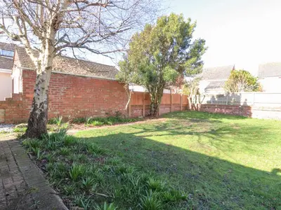 a yard with a tree and a brick wall at 38 Clive Avenue in Lytham St Annes