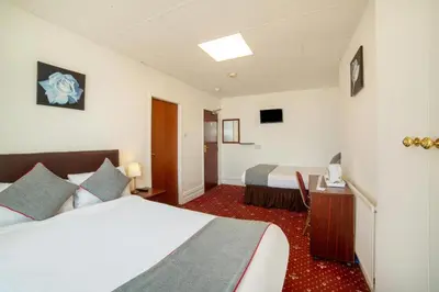a hotel room with two beds and a desk at HOTEL BLUE OCEAN - Call For Cheap Prices - Check In Until 3AM in Blackpool
