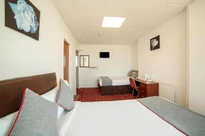 a hotel room with two beds and a desk at HOTEL BLUE OCEAN - Call For Cheap Prices - Check In Until 3AM in Blackpool