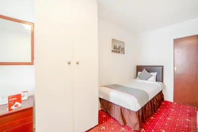 a small bedroom with a bed and a red rug at HOTEL BLUE OCEAN - Call For Cheap Prices - Check In Until 3AM in Blackpool