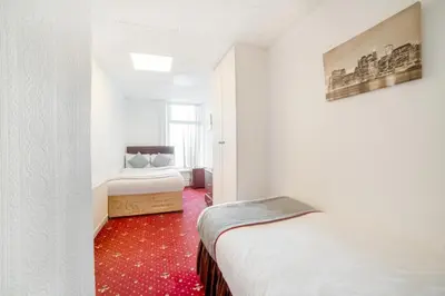 a bedroom with two beds and a red carpet at HOTEL BLUE OCEAN - Call For Cheap Prices - Check In Until 3AM in Blackpool