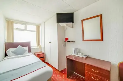 a bedroom with a bed and a dresser and a mirror at HOTEL BLUE OCEAN - Call For Cheap Prices - Check In Until 3AM in Blackpool