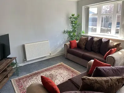a living room with two couches and a tv at A spacious 3 bed semi-detached in Ince-in-Makerfield