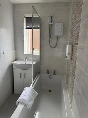 a white bathroom with a tub and a sink at A spacious 3 bed semi-detached in Ince-in-Makerfield