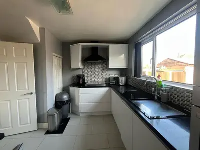 a kitchen with a sink and a window at A spacious 3 bed semi-detached in Ince-in-Makerfield