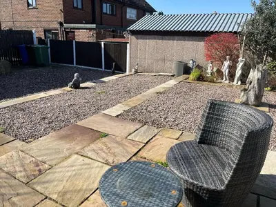 a chair sitting in a yard with a gravel yard at A spacious 3 bed semi-detached in Ince-in-Makerfield