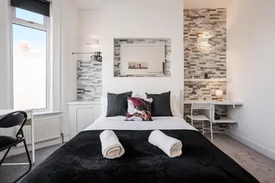 a bedroom with a large bed with a black blanket at 5-Bedroom House Long Stays Contractors Liverpool Hinkley Homes in Liverpool
