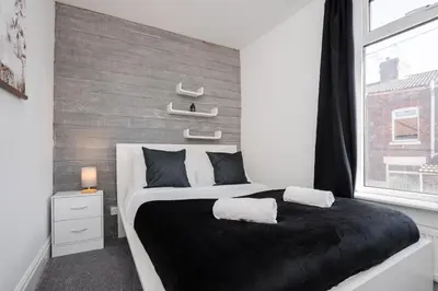 a bedroom with a large bed and a window at 5-Bedroom House Long Stays Contractors Liverpool Hinkley Homes in Liverpool