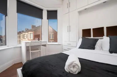 a bedroom with a large bed with a white towel on it at 5-Bedroom House Long Stays Contractors Liverpool Hinkley Homes in Liverpool