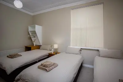 two twin beds in a room with a window at Hotel Sofia Blackpool in Blackpool
