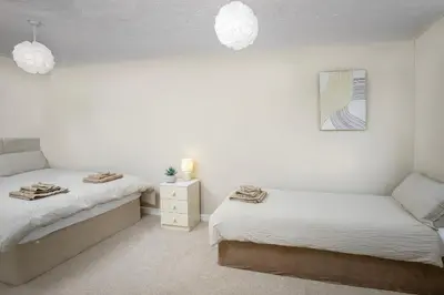 two beds in a room with white walls at Hotel Sofia Blackpool in Blackpool