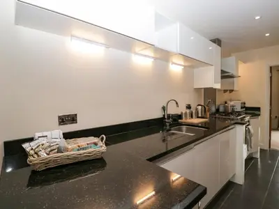 a kitchen with white cabinets and a basket on the counter at 7 Sandpiper in Carnforth