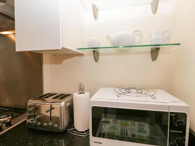 a kitchen counter with a toaster and a microwave at 7 Sandpiper in Carnforth