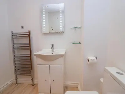 a bathroom with a sink and a mirror and a toilet at 7 Sandpiper in Carnforth