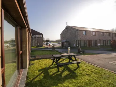 a picnic table sitting on the grass next to a building at 7 Sandpiper in Carnforth