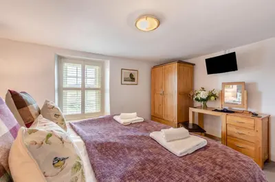 a bedroom with a bed and a dresser and a tv at 2 Bed in Field Broughton oc-l31021 in Cartmel