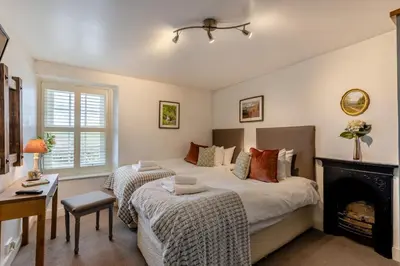 a bedroom with two beds and a fireplace at 2 Bed in Field Broughton oc-l31021 in Cartmel